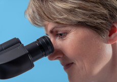 Employee looks into microscope